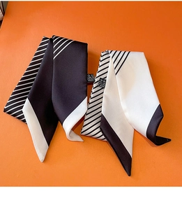 Detailed macro view of geometric striped silk scarves with contrast edges and care labels