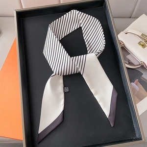 Classic black and white striped silk twilly scarf displayed in a luxury setting