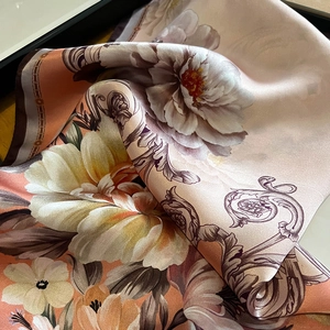 Detail of silk square scarf featuring vibrant peony floral prints and chain border