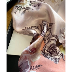 Macro view of silk square scarf featuring vintage floral patterns and satin texture