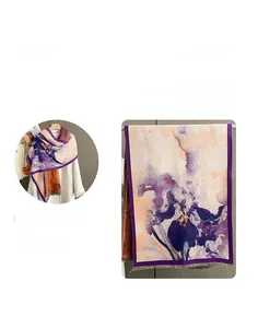 Dettaglio di sciarpa con stampa floreale astratta, toni viola e bordi con frange decorative