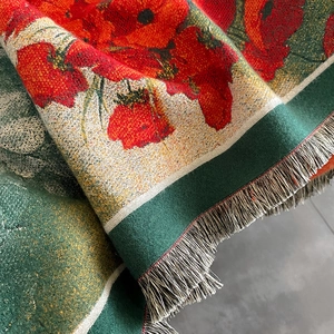 Macro shot showing detailed red flower jacquard weaving and thick tassel edge on scarf