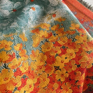 Close-up of thick jacquard woven fabric with oil painting style floral patterns and fringe