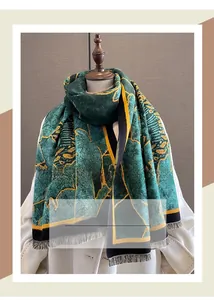 Detail of winter thick scarf featuring green and gold abstract patterns with fringes