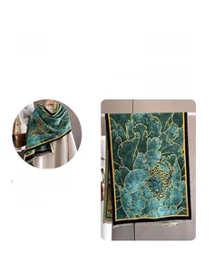 Detail view of winter scarf featuring emerald floral pattern and thick cashmere-like texture