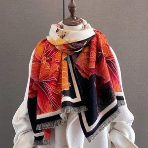 Artistic floral cashmere-like scarf with tassels over a white coat on a mannequin