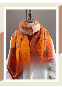 Detail of printed cashmere-like scarf with autumn leaf patterns and fringe edges