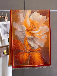 Detail of floral printed scarf with fringe, featuring orange and brown gradient tones