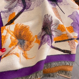 Close-up of floral cashmere feel scarf with vibrant purple patterns and fine tassels