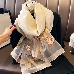 Détail d'une écharpe en soie et laine avec broderie florale et patchwork d'organza