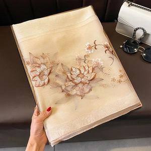 Détail de l'écharpe en soie champagne avec broderie florale dorée et bordures pailletées