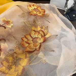 Gros plan sur la broderie florale du châle élégant en soie et laine champagne