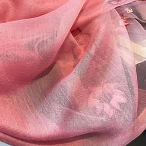 Gros plan détaillé d'une écharpe en soie et laine rose avec broderie florale fine