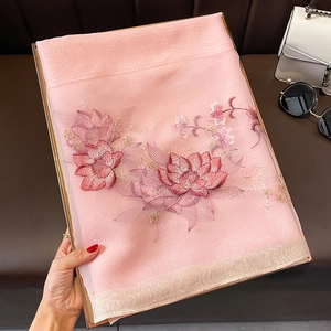 Détail de la broderie florale rose sur un châle en soie et laine avec bords métalliques