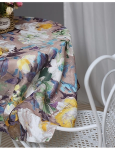 Detail of round waterproof tablecloth with vintage floral print and linen texture