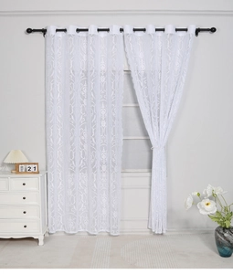 Close-up of white damascus lace curtain with metal grommets and intricate floral texture