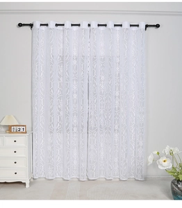 Detail of white lace curtain with Damascus embroidery and metal grommet top design