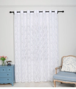 Detail of white lace curtain featuring damascus embroidery and metal grommets finish