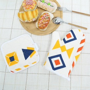 Nordic oven mitt and pot holder set with colorful geometric patterns on white cotton