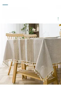 Detail of Nordic linen tablecloth featuring vertical stripes and white tassel trim
