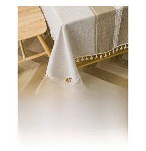 Detail of Nordic striped table runner featuring delicate beige tassels on wooden table