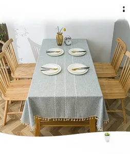 Detail of grey cotton linen tablecloth with white stripes and elegant tassel edge decoration