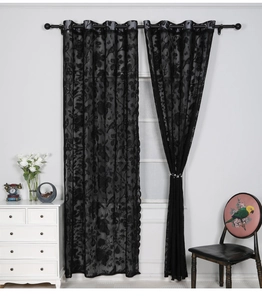 Detailed macro view of black lace curtain with floral patterns and silver metal grommets