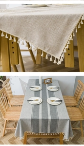 Detail of Nordic striped tablecloth with elegant white tassels and cotton linen texture