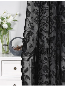 Close-up of black lace curtain featuring intricate floral and bird embroidery patterns