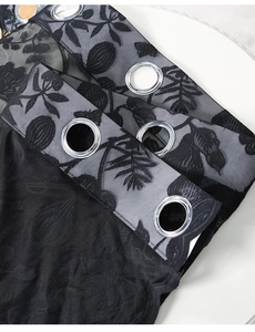 Detail of black lace curtain fabric with floral embroidery and silver metal grommets