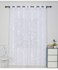 Detail of white floral lace curtain with metal eyelets and intricate hollow patterns