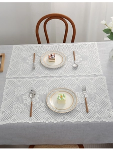 Detailed macro view of pure white lace table placemats with vintage crochet hollow pattern
