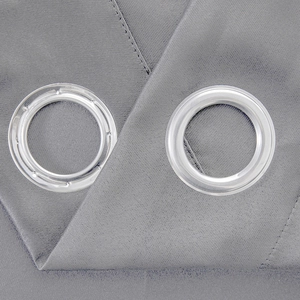 Detail of grey blackout curtain fabric texture with round plastic grommet rings