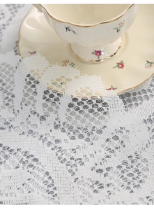 Macro detail of white floral lace placemat with elegant vintage tea cup and saucer