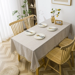Nordic beige striped tablecloth with white embroidery and fringe on a wooden table