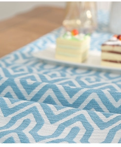 Close-up of blue and white geometric jacquard table runner with soft woven texture