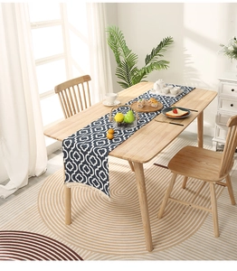 Detail of dark blue geometric table runner with white Moroccan patterns and tassels