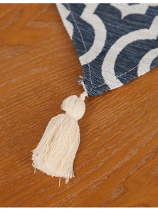 Close-up of chenille table runner featuring blue geometric patterns and white fringe