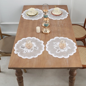 Set of 4 white round lace placemats with floral crochet pattern on wooden table