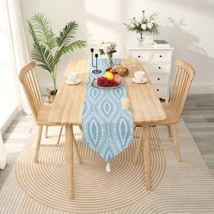Blue geometric jacquard table runner with white leaf patterns and stylish tassel decor