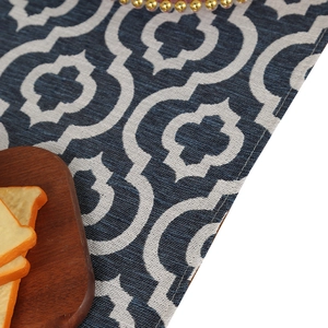 Blue and white quatrefoil table runner with geometric woven texture and stitched edges