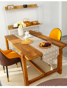 Detail of geometric herringbone table runner with tassel fringe on a wooden table