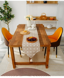 Detail of beige and khaki chevron table runner featuring elegant white tassel edges