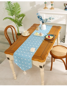 Close-up of geometric blue and white table runner with decorative white tassels