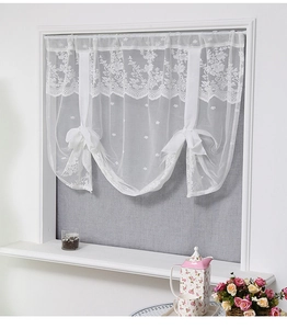 Detail of white floral lace short curtain featuring elegant ribbon bows and scalloped edge