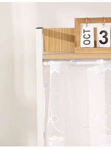 Detailansicht eines weißen Spitzenvorhangs mit feiner Blumenstickerei und Stangendurchzug