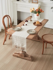 Detail of jacquard geometric pattern table runner with elegant handmade tassels