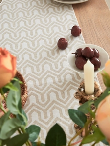 Macro detail of jacquard table runner with geometric woven patterns on wooden desk