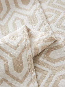 Detailed macro view of beige jacquard woven fabric with geometric diamond pattern texture