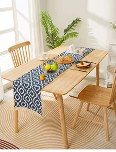 Close-up of deep blue Moroccan table runner with white geometric patterns and tassels